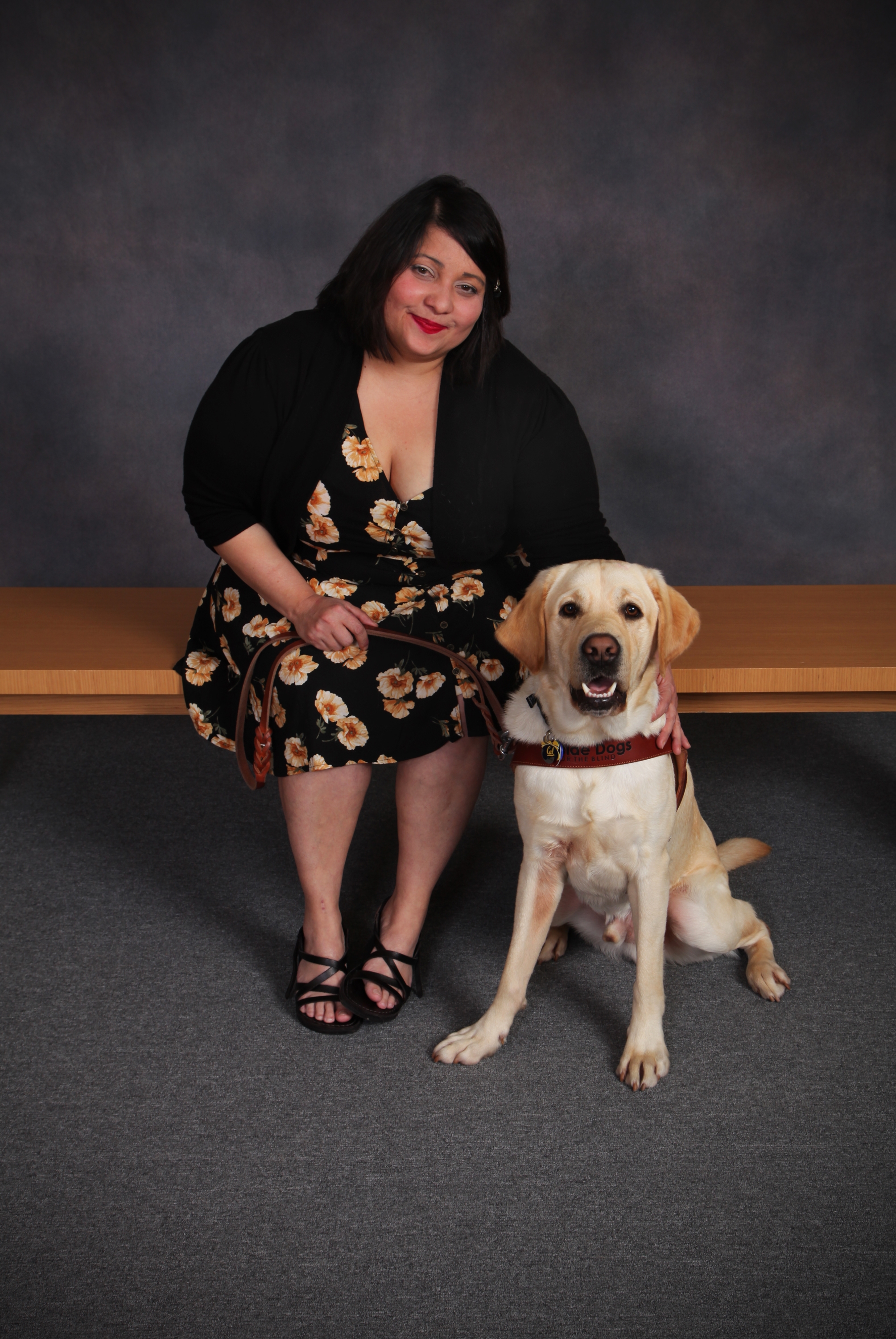 Melba is seated beside yellow Lab guide dog, Chad, in their formal class graduation photo.