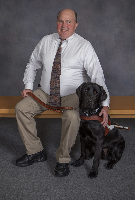 Portrait of Pete Berg with his black Lab guide, Lloyd.