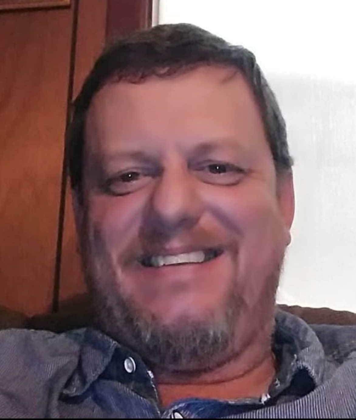 Headshot of a smiling man.