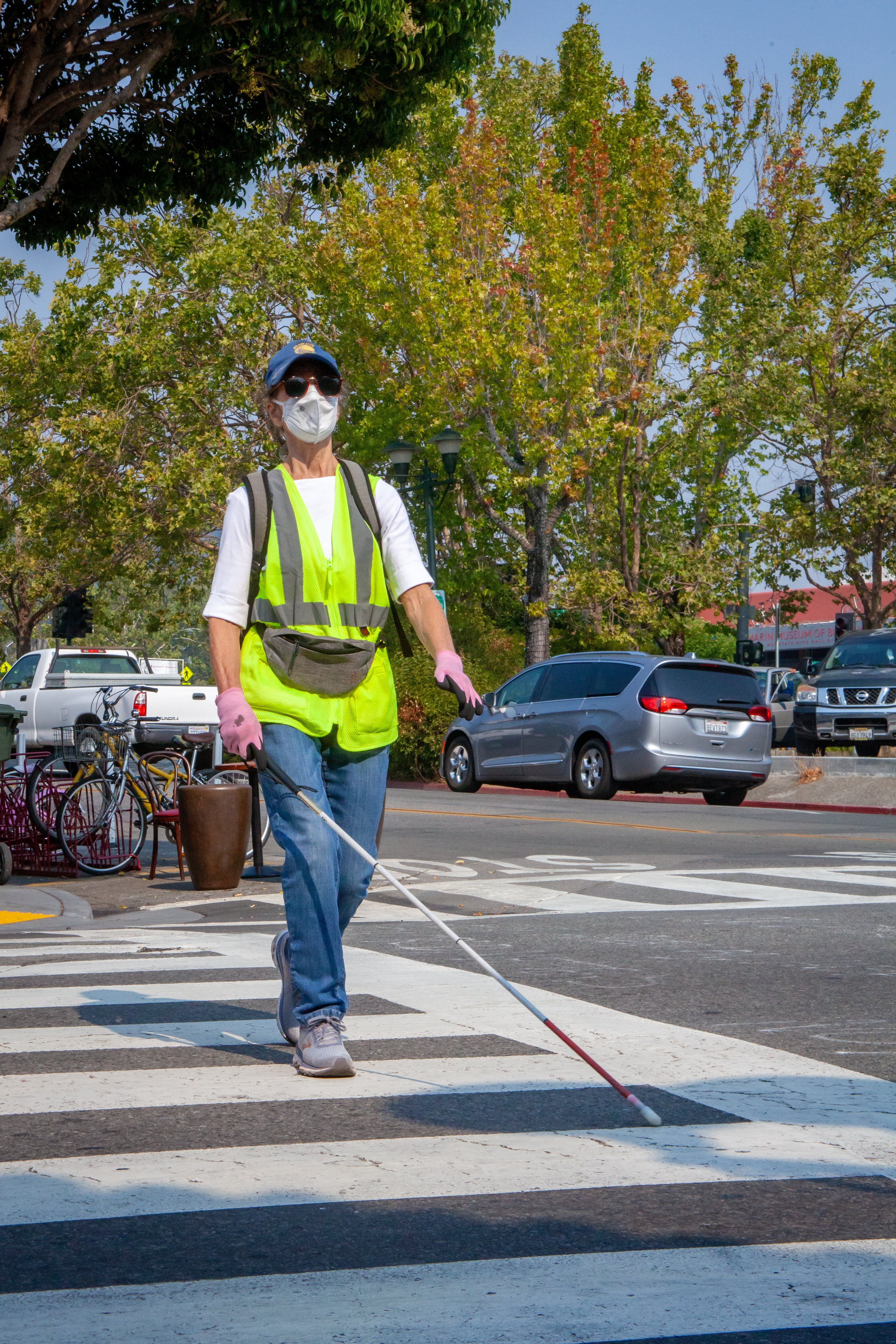 Marta Van Leuven walking with her white cane in a crosswalk.