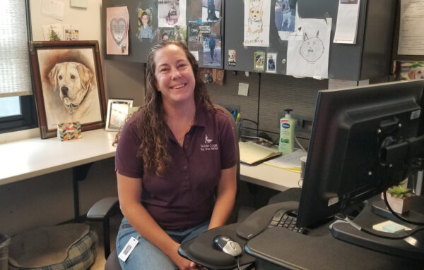 Dr. Matern sits in her work cubicle surrounded by thank-you cards on the walls.