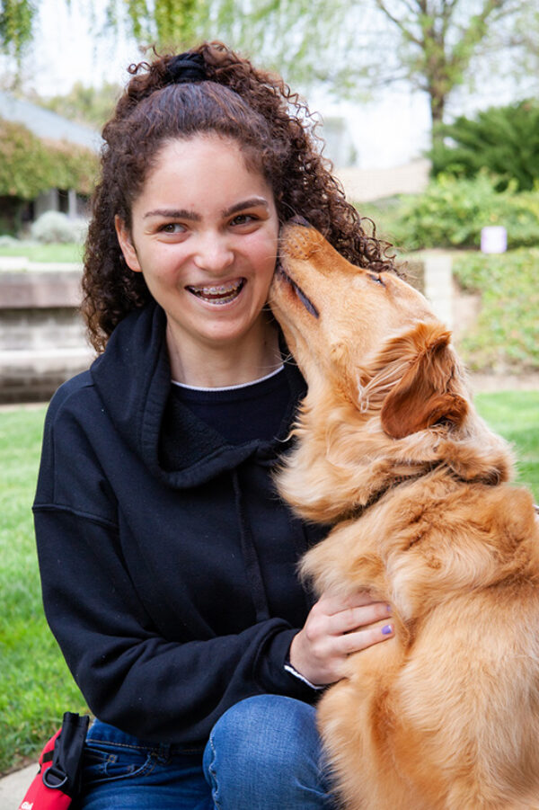 Jayna gets a kiss on the cheek from her K9 Buddy, Golden Retriever Kendo.