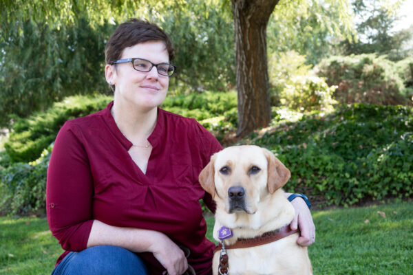 Kristen Ingalz sits next to her guide dog.