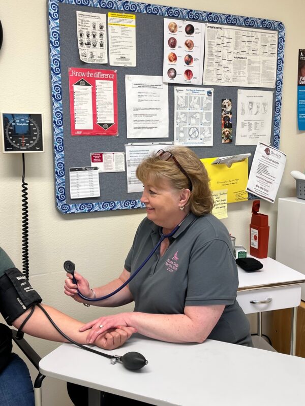 Nurse Debbie Knapp takes a client's blood pressure during an intake exam. They are stated in the on-site nursing office.