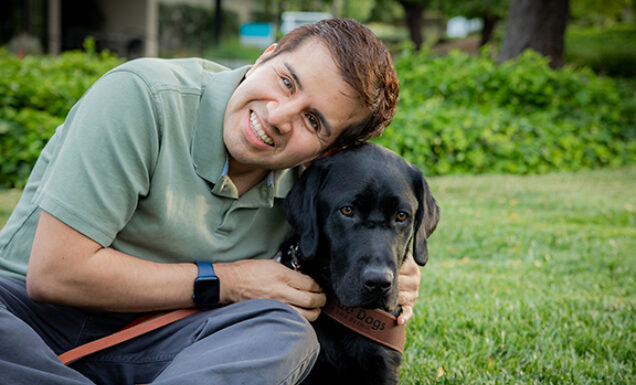 Belo Miguel Cipriani hugs his black Lab guide dog, Limo