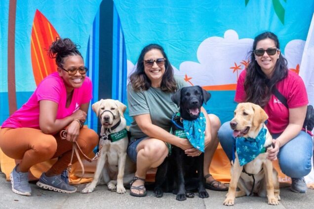 Three volunteer puppy raisers pose for a photo at Fun Day.
