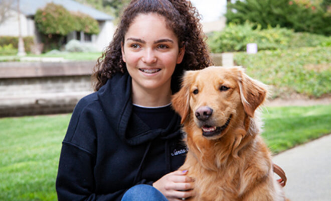 A young girl with a Golden Retriever K9 Buddy dog.