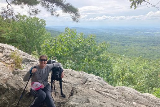 Mary Wilson sits beside her black Lab guide dog, Thor, along the Appalachian Trail.