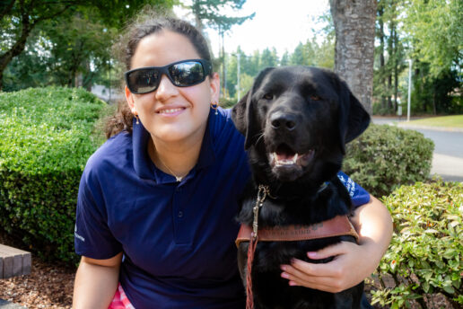 Program participant embraces a black Lab guide dog.