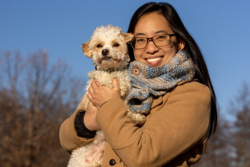 Dr. Lynna Feng holds her white dog in an embrace.