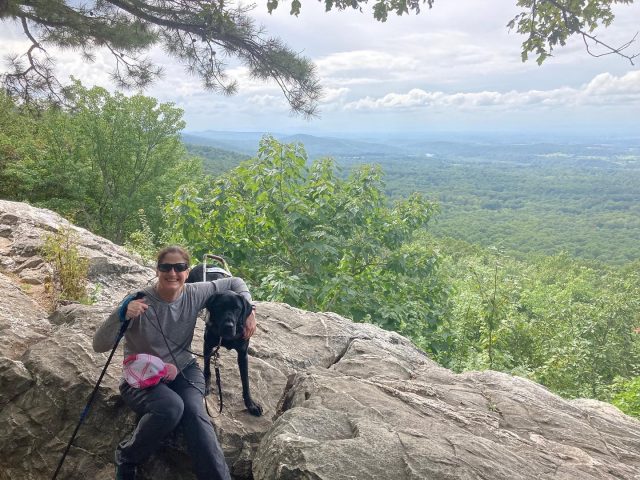 Mary Wilson sits beside her black Lab guide dog, Thor, along the Appalachian Trail.