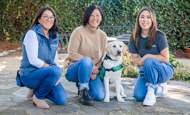 Three women and a yellow Lab guide dog puppy.