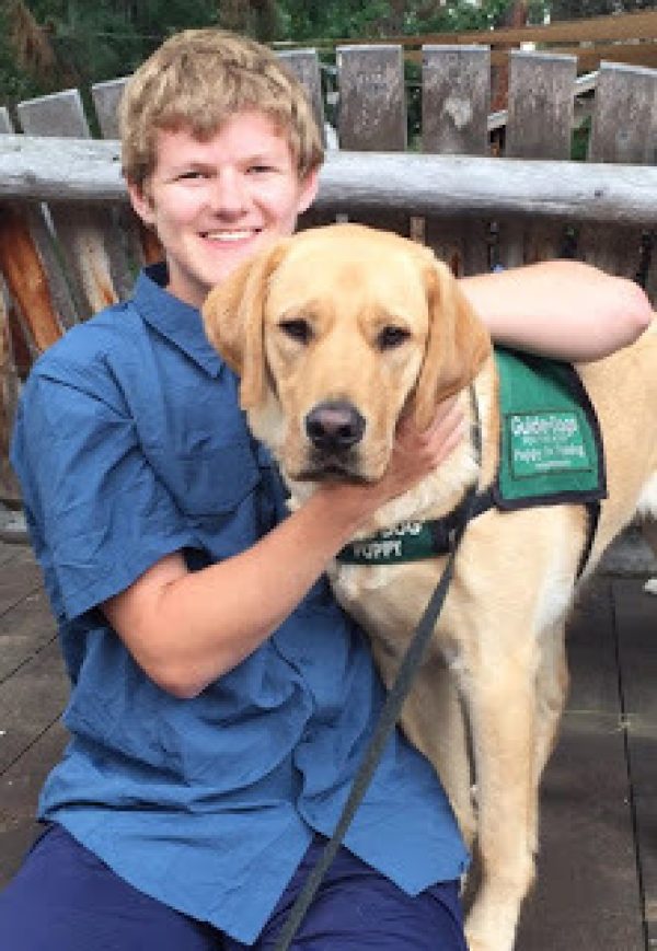 Sam Nelson with a yellow Lab guide dog puppy.