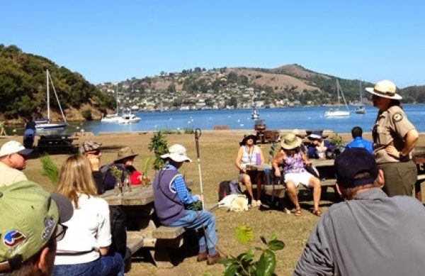 Ranger Casey Dexter Lee greets the Foggy Doggies group on a beautiful sunny day with the bay in the background.