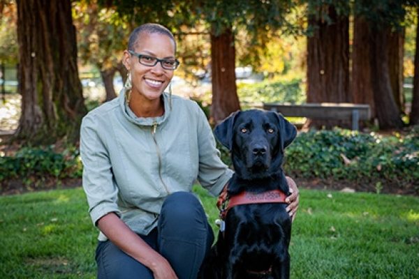 Guide Dog Mobility Instructor Calone Nathaniel with a black Lab guide dog.