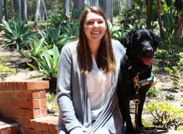 Christina with a black Lab guide dog puppy.