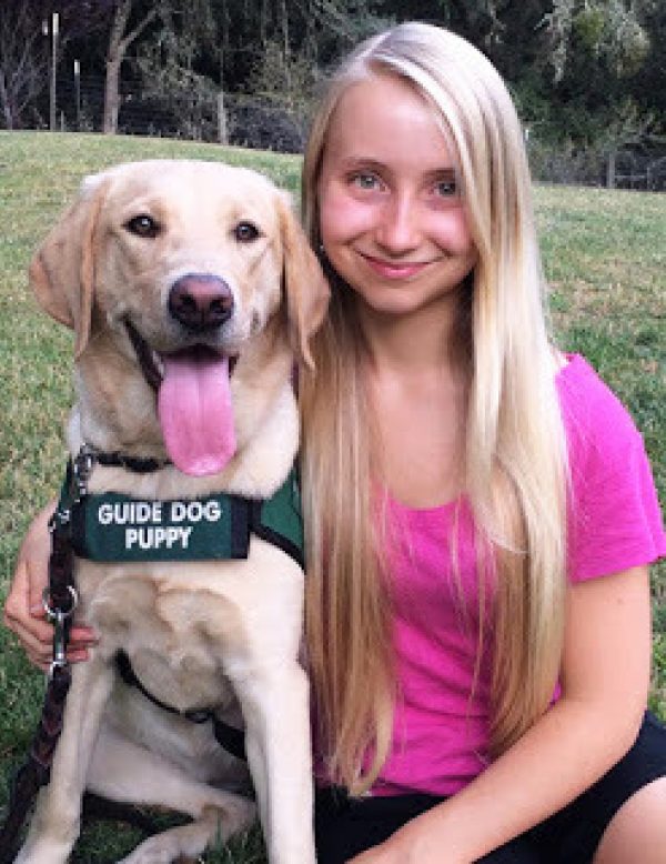 Hailey with a yellow Lab guide dog puppy.